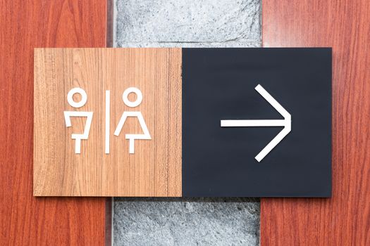 Unisex restroom or toilet and arrow sign on wall style boutique .