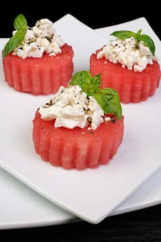 Appetizer of watermelon with ricotta and basil and spices