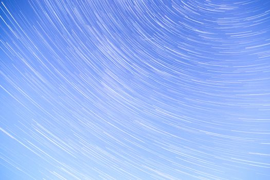 Star Trails streaking across a Blue Sky.