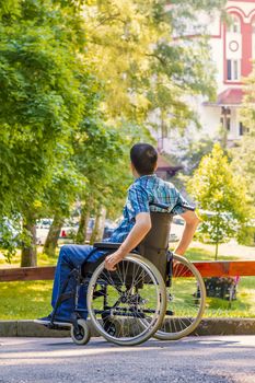 young man in wheelchair in city park