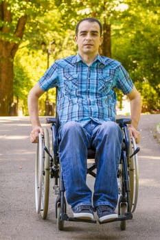 young man in wheelchair in city park