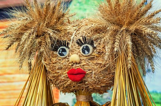 Funny doll made of straw and ears of wheat with eyes , eyelashes, mouth of papier-mache.
