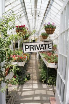 A bright greenhouse with a "private" sign.