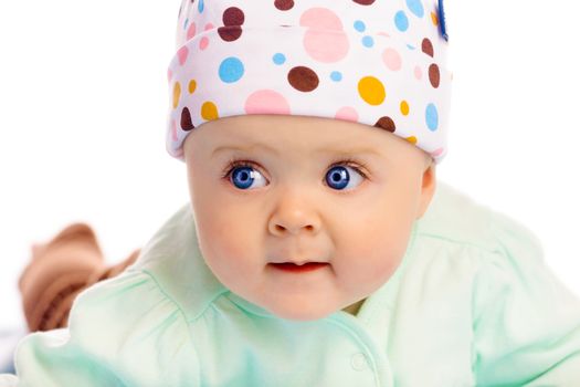 Beautiful blue-eyed baby in the cap. Close-up. Studio photo