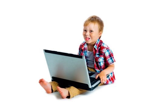 The little boy with a laptop sitting on the floor