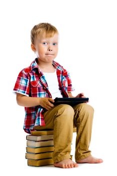 Little boy with a Tablet PC sitting on the books