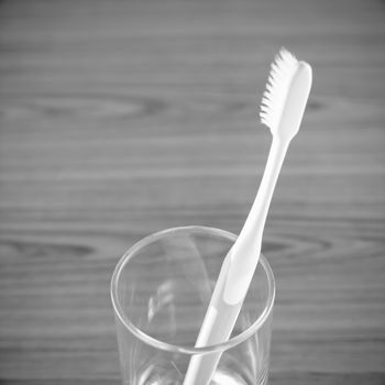 toothbrush in glass on wood background black and white color tone style