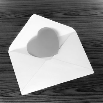 heart with envelope on wooden background black and white color tone style