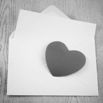 heart with envelope on wooden background black and white color tone style