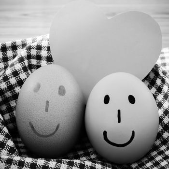 smile love egg couple in brown kitchen towel on wood table black and white color tone style