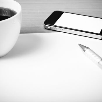 paper and pen with coffee cup and smart phone on wood background black and white color tone style