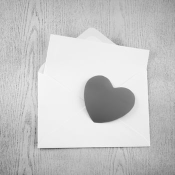 heart with envelope on wooden background black and white color tone style