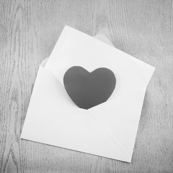 heart with envelope on wooden background black and white color tone style