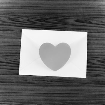 heart with envelope on wooden background black and white color tone style