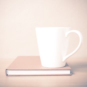 book and coffee mug on wood background vintage style