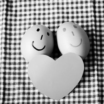 smile love egg couple in brown kitchen towel on wood table black and white color tone style