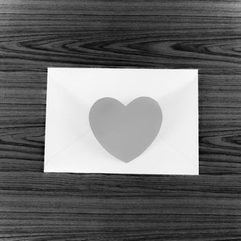 heart with envelope on wooden background black and white color tone style