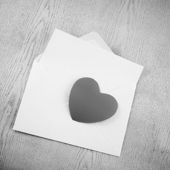 heart with envelope on wooden background black and white color tone style