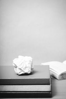 book and crumpled paper on wood background black and white color tone style