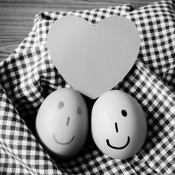 smile love egg couple in brown kitchen towel on wood table black and white color tone style