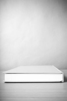 orange book on wood table background black and white color tone style