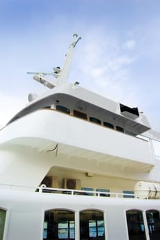 White tourist ship close up against blue sky.