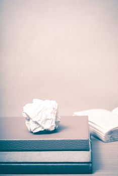 book and crumpled paper on wood background vintage style