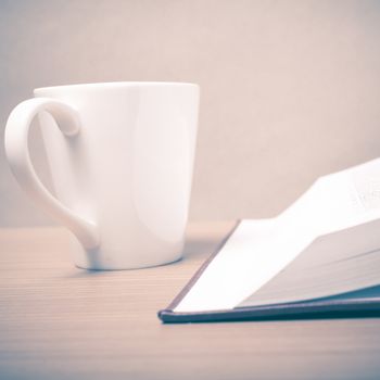 book and coffee mug on wood background vintage style