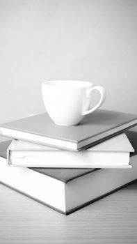 stack of book with coffee cup on wood table background black and white color tone style