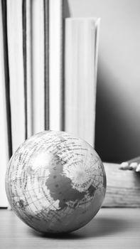 book and earth ball with color pencil on wood background black and white color tone style