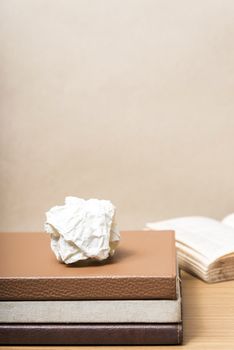 book and crumpled paper on wood background