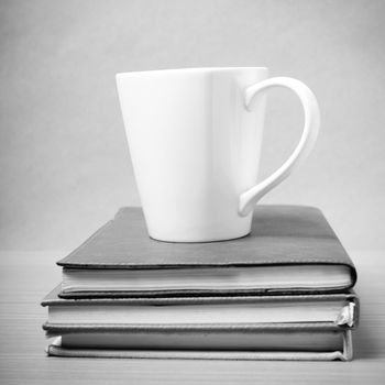 stack of book with coffee mug on wood background black and white tone style