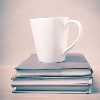 stack of book with coffee mug on wood background vintage style