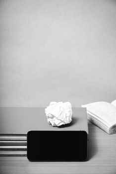 stack of book with smart phone on wood background black and white color tone style