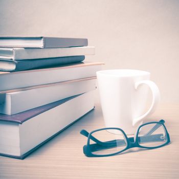 stack of book with coffee mug on wood background vintage style