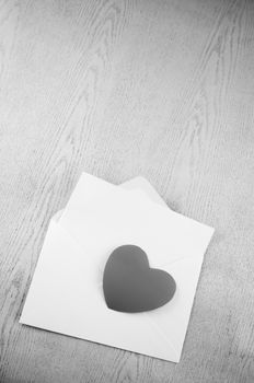 heart with envelope on wooden background black and white color tone style