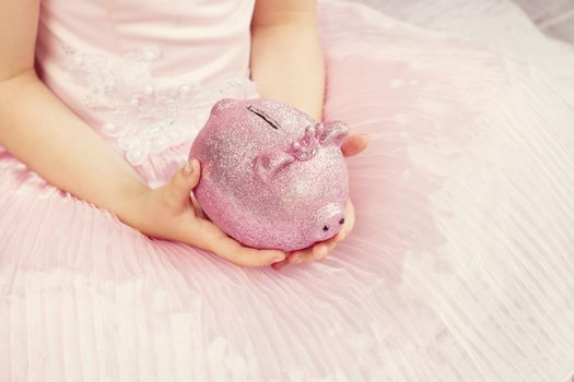 Pink piggy bank in the children's hands. toning