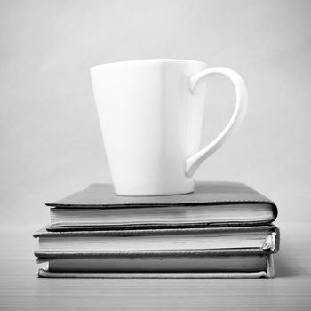 stack of book with coffee mug on wood background black and white tone style