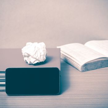 stack of book with smart phone on wood background vintage style