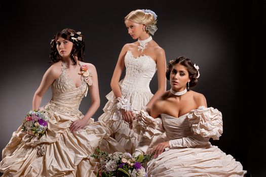 Three young beautiful women in wedding dresses
