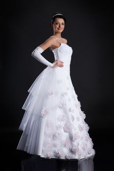 Young beautiful woman in a wedding dress on a studio background