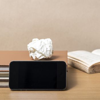 stack of book with smart phone on wood background