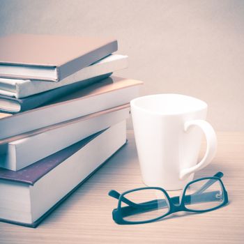 stack of book with coffee mug on wood background vintage style