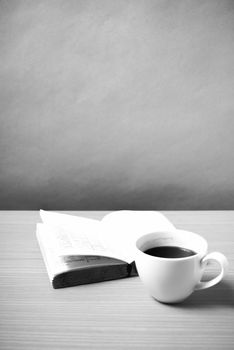 open book with coffee on wood background black and white color tone style