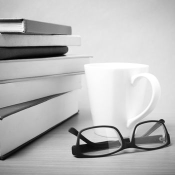 stack of book with coffee mug on wood background black and white tone style