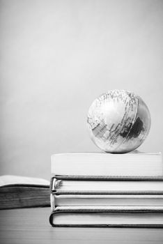 book and earth ball on wood background black and white color tone style