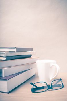 stack of book with coffee mug on wood background vintage style