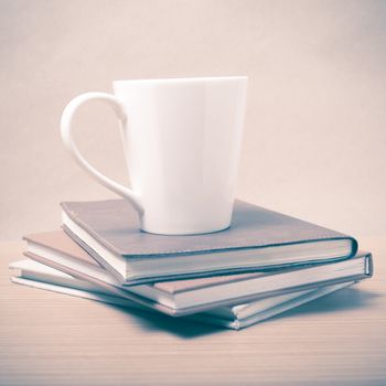 stack of book with coffee mug on wood background vintage style