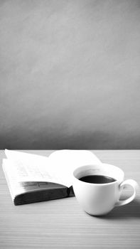open book with coffee on wood background black and white color tone style