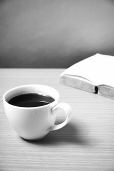 open book with coffee on wood background black and white color tone style